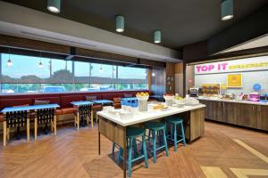 a restaurant with tables and chairs and a top it counter at Tru By Hilton Denver, PA in Denver