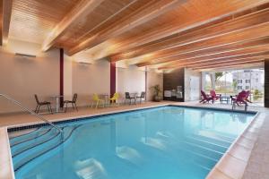 a swimming pool in a hotel with chairs and tables at Home2 Suites By Hilton Lancaster in Lancaster