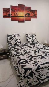 ein Bett in einem Schlafzimmer mit Plakaten an der Wand in der Unterkunft Jolie petite maison tout équipée in Le Gosier
