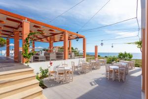 a patio with tables and chairs and the ocean in the background at Maria Beach House in Dhamoulianáta