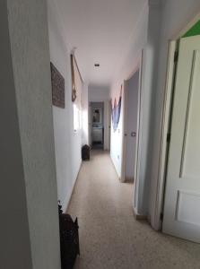 a hallway with white walls and a white door at Ático en Barbate in Barbate