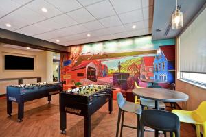 Tru By Hilton Denver, PA في Denver: غرفة ألعاب مع لوحة جدارية لحظيرة