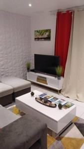 ein Wohnzimmer mit einem Sofa und einem Tisch in der Unterkunft Jolie petite maison tout équipée in Le Gosier