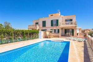 a villa with a swimming pool in front of a house at Villa Alicia in Portocolom