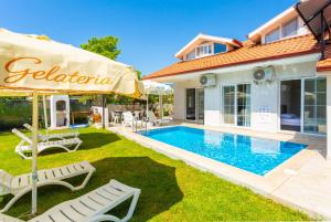 un patio trasero con piscina y una casa en Villa Zonkdemir en Dalyan