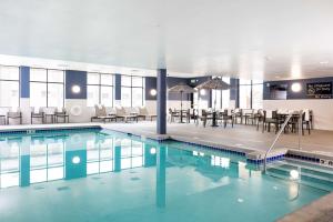 a swimming pool with tables and chairs in a building at Hampton Inn and Suites La Crosse Downtown in La Crosse