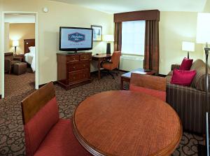 a hotel room with a table and a television at Hampton Inn Littleton in Littleton