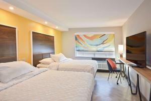 a hotel room with two beds and a flat screen tv at Tru By Hilton Lawrence in Lawrence