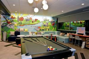 a pool table in a room with a mural at Tru By Hilton Lawrence in Lawrence