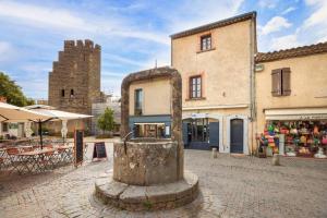 un bâtiment avec une fontaine au milieu d'une rue dans l'établissement Le Nid d'Arthur, à Carcassonne