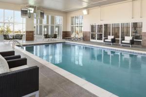 a large swimming pool with blue water in a building at Hampton Inn Lawrence in Lawrence