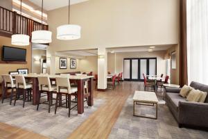 a dining room and living room with tables and chairs at Hampton Inn Lawrence in Lawrence