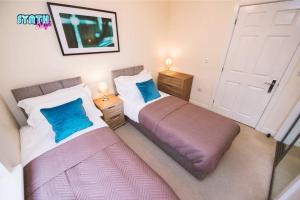 two beds sitting next to each other in a bedroom at Spacious Central Leatherhead Apt Long Term Stay in Leatherhead