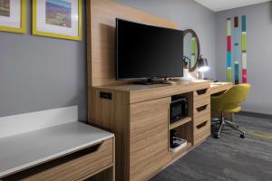 Zimmer mit einem TV und einem Schreibtisch mit Stuhl in der Unterkunft Hampton Inn Gretna - Smith Mountain Lake in Gretna