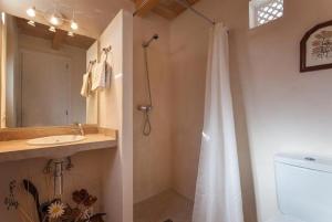 ein Bad mit einem Duschvorhang und einem Waschbecken in der Unterkunft Can Llobera Private Pool AC WiFi in Pollença