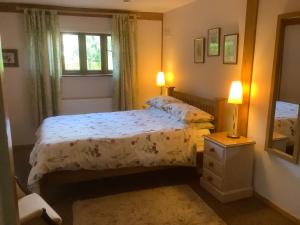 a bedroom with a bed and two lamps and a mirror at The Oak Lodge, Clematis Cottages, Stamford in Stamford