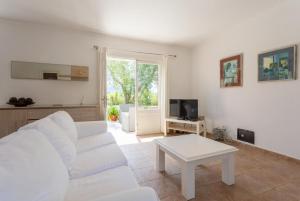 - un salon avec un canapé blanc et une table dans l'établissement Villa La Torre, à Alcúdia