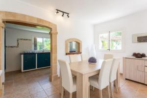a kitchen and dining room with a wooden table and chairs at Villa La Torre in Alcudia