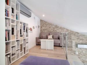 - un salon avec un canapé et une étagère à livres dans l'établissement Aurore Duplex - New Apartment, à Lisbonne