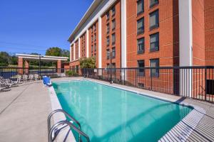 a swimming pool in front of a building at Hampton Inn Martinsburg in Martinsburg