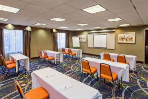uma sala de conferências com mesas brancas e cadeiras laranja em Hampton Inn and Suites Merced em Merced