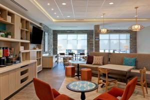 特洛克Home2 Suites By Hilton Turlock, Ca的一间配有沙发和桌椅的等候室