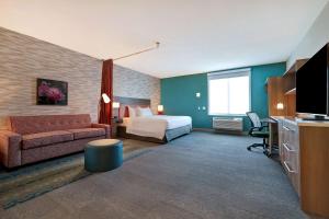 um quarto de hotel com uma cama e um sofá em Home2 Suites By Hilton Turlock, Ca em Turlock
