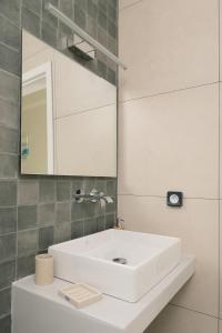a bathroom with a white sink and a mirror at Villa Petra in Trapezaki