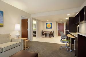 Home2 Suites By Hilton Leavenworth Downtown في ليفنورث: غرفة معيشة مع أريكة وغرفة طعام