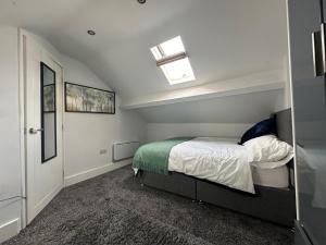 a small bedroom with a bed and a window at THE GLASS HOUGHTON APARTMENTS in Castleford