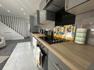 a kitchen with a stove and a counter top at THE GLASS HOUGHTON APARTMENTS in Castleford