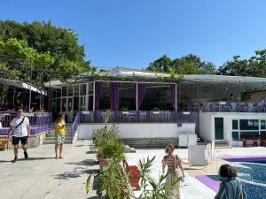 a group of people walking around a swimming pool at Парк-хотел РИВА in Golden Sands