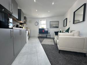 a kitchen and living room with a couch and a tv at THE GLASS HOUGHTON APARTMENTS in Castleford