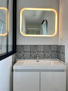 uma casa de banho com um lavatório branco e um espelho. em PENTY em Porsmilin