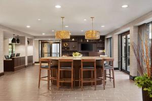a kitchen with a large wooden table and chairs at DoubleTree by Hilton McLean Tysons in Tysons Corner +52 photos