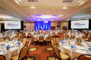a banquet hall with tables and chairs and two screens at Hilton Garden Inn Independence in Independence +44 photos