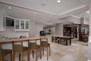 a kitchen with a bar with chairs and a table at Hilton Garden Inn Overland Park in Overland Park