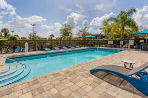 a swimming pool with lounge chairs in a resort at Hampton Inn & Suites Orlando International Drive North in Orlando