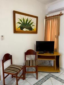 a living room with a desk with a tv and two chairs at Quinta Sea in Playa del Carmen