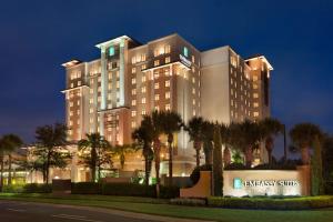 基西米Embassy Suites by Hilton Orlando Lake Buena Vista South的一座前面有棕榈树的大楼
