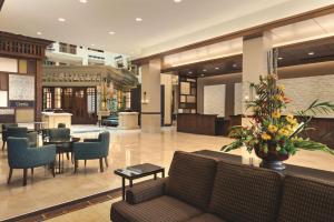 vestíbulo con sofá, mesa y sillas en Embassy Suites by Hilton Orlando Lake Buena Vista South, en Kissimmee