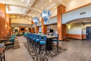 uma área de jantar com cadeiras e mesas azuis num restaurante em Hampton Inn & Suites Orlando-South Lake Buena Vista em Kissimmee