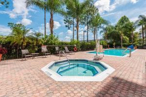 bañera de hidromasaje en un patio de ladrillo junto a la piscina en Hampton Inn & Suites Orlando-South Lake Buena Vista, en Kissimmee