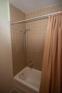 e bagno con doccia, lavandino e vasca. di Hotel Evernia a West Palm Beach