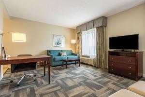 キシミーにあるHampton Inn & Suites Orlando-South Lake Buena Vistaのデスクとテレビが備わるホテルルームです。
