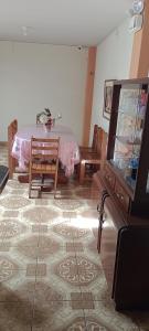 a living room with a table and a tv at Travelershouse Casa Hospedaje in Huanchaco