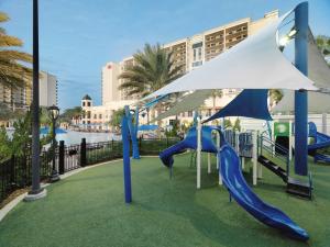 a playground with blue slides and an umbrella at Parc Soleil by Hilton Grand Vacations in Orlando