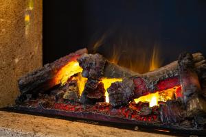 a fire is burning in a stone fireplace at AL RANCH WELLNESS CADORE DOLOMITI APARTMENTS vicino Cortina e Misurina Tre Cime Lavaredo in Pieve di Cadore
