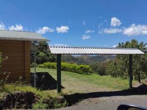un pavillon avec un toit blanc à côté d'un bâtiment dans l'établissement Monteverde Monte Green, à Monteverde Costa Rica