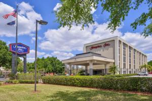 a hotel with an american flag in front of a building at Hampton Inn Closest to Universal Orlando in Orlando